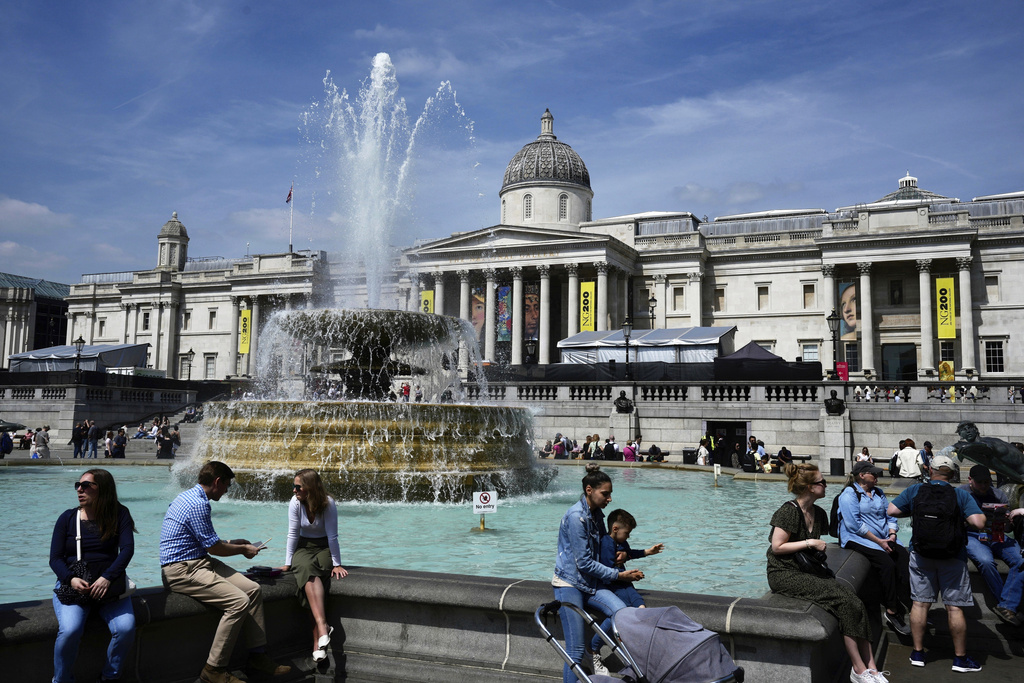 FILE - People sit near a fountain outside of the National Gallery in London, Friday, May 10, 2024. (AP Photo/Kin Cheung, File)