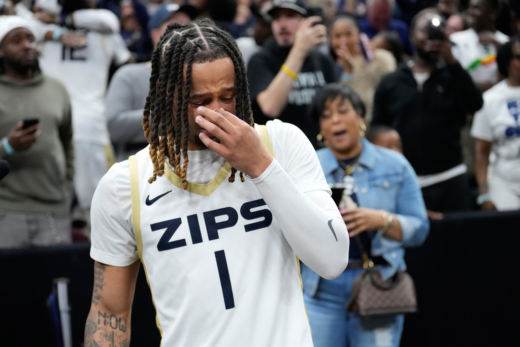 Akron guard Shammah Scott cries after hugging his mother, Anaija Scott, rear, after Akron defeated Toledo in an NCAA college basketball game in the championship of the Mid-American Conference tournament, Saturday, March 14, 2026, in Cleveland. (AP Photo/Sue Ogrocki)