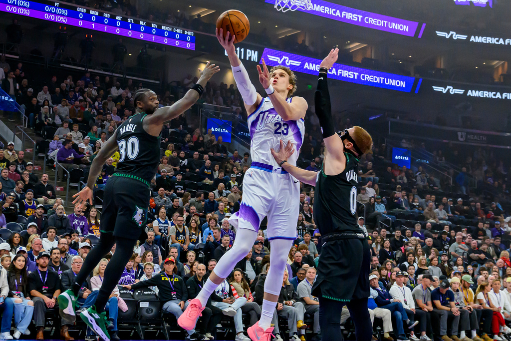 Utah Jazz forward Lauri Markkanen (23) drives to the basket guarded by Minnesota Timberwolves forward Julius Randle (30) and Minnesota Timberwolves guard Donte DiVincenzo (0) during the first half of an NBA basketball game, Monday, Nov. 10, 2025, in Salt Lake City. (AP Photo/Tyler Tate)