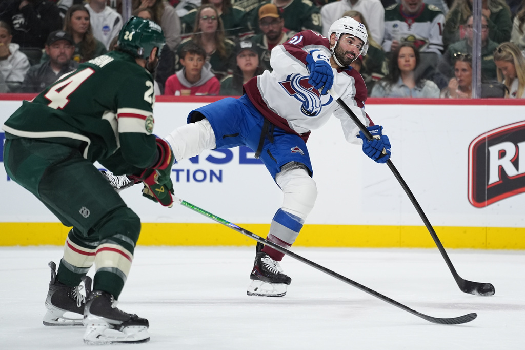 Colorado Avalanche center Nazem Kadri, right, shoots while defended by Minnesota Wild defenseman Zach Bogosian (24) during the second period of Game 3 of an NHL Stanley Cup hockey second-round playoff series Saturday, May 9, 2026, in St. Paul, Minn. (AP Photo/Abbie Parr)