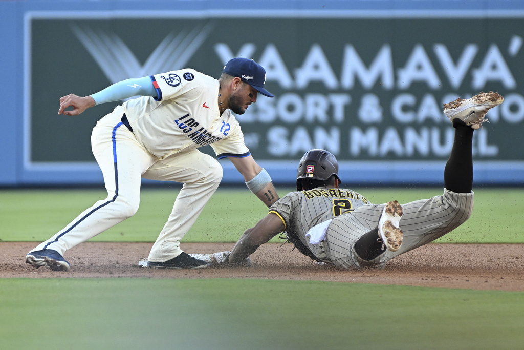 Los Angeles Dodgers second baseman Miguel Rojas, left, tags out San Diego Padres Xander Bogaerts (2) on a steal-attempt at second during the second inning of a baseball game Saturday, Aug. 16, 2025, in Los Angeles. (AP Photo/Wally Skalij)
