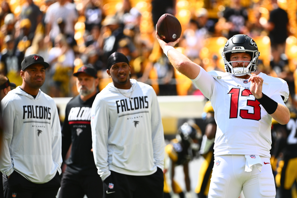 Atlanta Falcons quarterback Cooper Rush (13) warms up with Atlanta Falcons quarterback Tua Tagovailoa (1) and Atlanta Falcons quarterback Michael Penix Jr. (9) behind him before an NFL football game, Sunday, Sept. 13, 2026, in Pittsburgh. (AP Photo/Justin Berl)