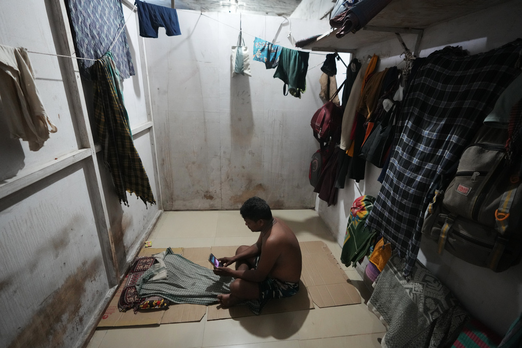 Sibaram Pradhan, a power loom factory worker, makes a video call to his family at his residential quarters in Surat, India, Thursday, May 28, 2026. (AP Photo/Ajit Solanki)