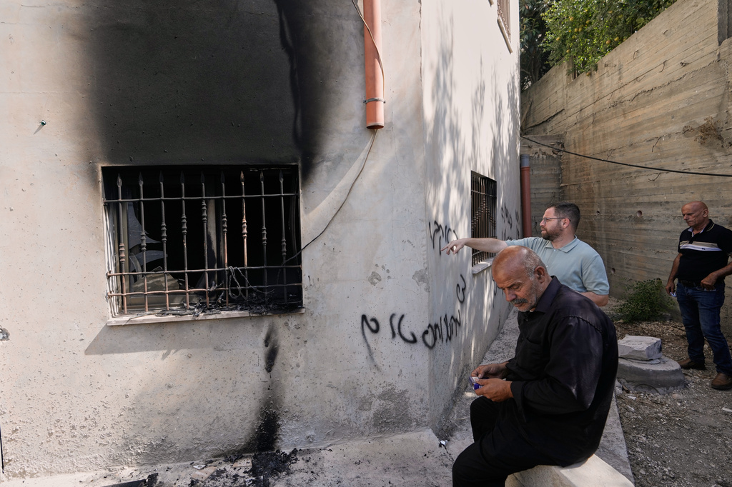 Palestinians check the damage to a mosque that, according to residents, was burned during an attack by Israeli settlers, in the West Bank village of Bazariya, Tuesday, Sept. 1, 2026, as on its wall a Hebrew graffiti reads "Huckabee regards from the terrorists", referring to the U.S. Ambassador to Israel, Mike Huckabee. (AP Photo/Majdi Mohammed)