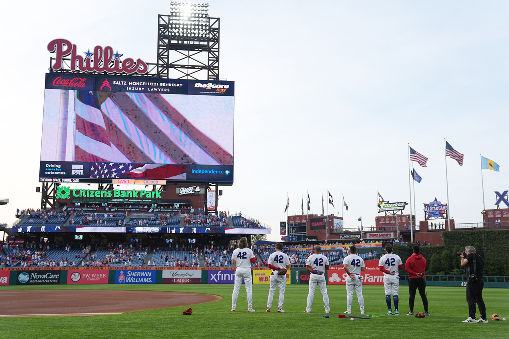 Members of the Philadelphia Phillies, wearing No. 42 to commemorate Jackie Robinson Day, stand for the National Anthem ahead of a baseball game against the Chicago Cubs, Wednesday, April 15, 2026, in Philadelphia. (AP Photo/Matt Rourke)