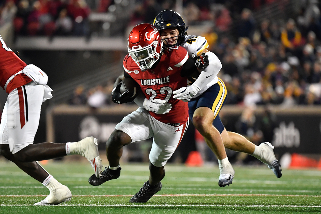 Louisville running back Keyjuan Brown (22) is tackled by California linebacker Luke Ferrelli (41) (41) during overtime of an NCAA college football game in Louisville, Ky., Saturday, Nov. 8, 2025. (AP Photo/Timothy D. Easley)