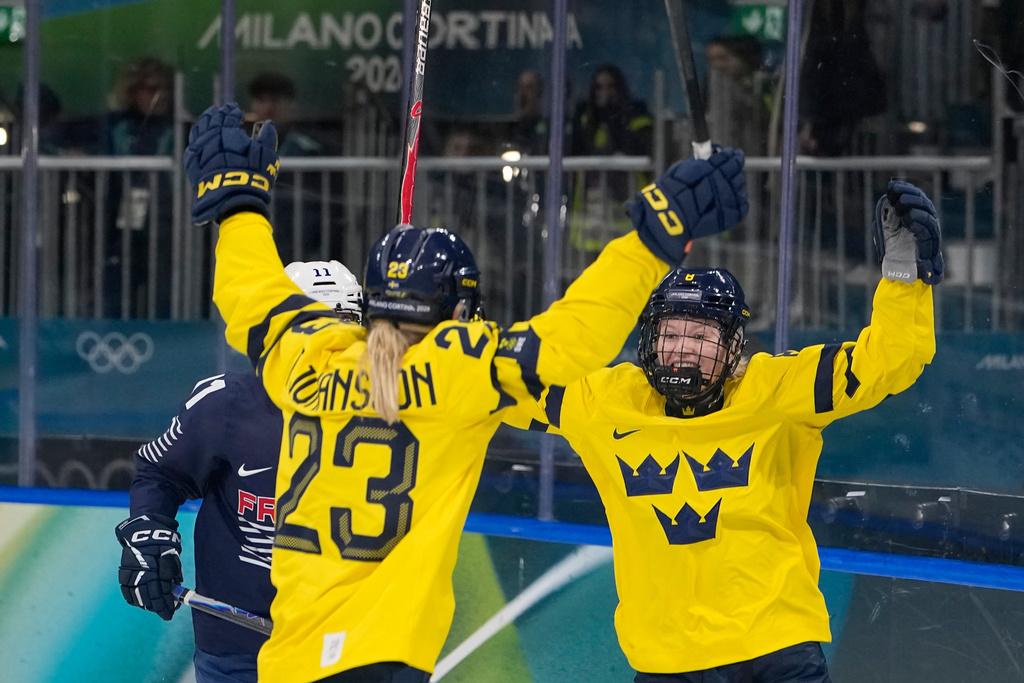 Sweden's Thea Johansson, left, celebrates after scoring her side's opening goal during a preliminary round match of women's ice hockey between the France and Sweden at the 2026 Winter Olympics, in Milan, Italy, Sunday, Feb. 8, 2026. (AP Photo/Petr David Josek)