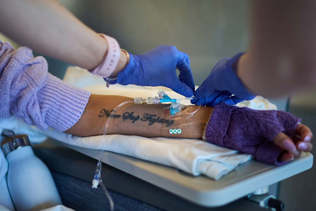 A tattoo reading "Never Stop Fighting" decorates the arm of Ruth Wilson, as she receives her monthly lupus-focused IV treatment at UMass Memorial Medical Center, Tuesday, Jan. 14, 2025, in Worcester, Mass. (AP Photo/David Goldman)