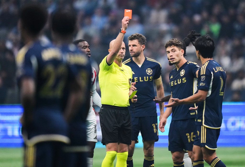 Referee Allen Chapman issues a red card to Vancouver Whitecaps' Mathias Laborda, front right, as Thomas Muller, back center, and Sebastian Berhalter, back right, look on during the first half of an MLS soccer match against FC Dallas in Vancouver on Saturday, Oct. 18, 2025. (Darryl Dyck/The Canadian Press via AP)