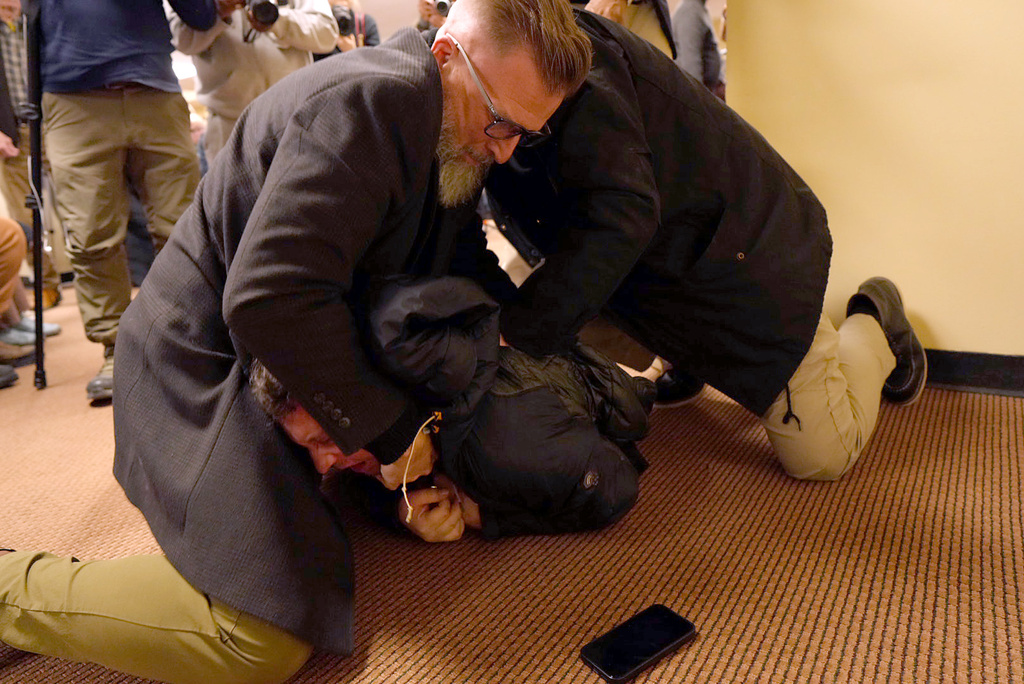 A man is tackled to the ground after spraying an unknown substance on U.S. Rep. Ilhan Omar, D-Minn., during a town hall on Tuesday, Jan. 27, 2026, in Minneapolis. (Richard Tsong-Taatarii/Star Tribune via AP)