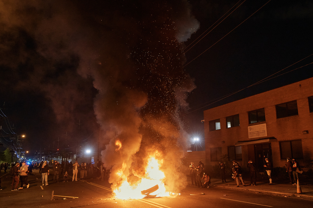 People watch a burning barricade near the Delaney Hall detention center during a protest against the transfer of detainees and federal immigration policies on Saturday, May 30, 2026, in Newark, N.J. (AP Photo/Andres Kudacki)