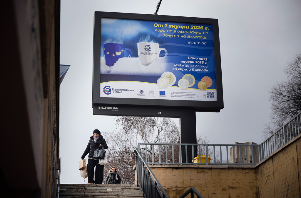 A woman passes by a billboard displaying Eurozone information campaign in Sofia, Saturday, Dec. 27, 2025. (AP Photo/Valentina Petrova)