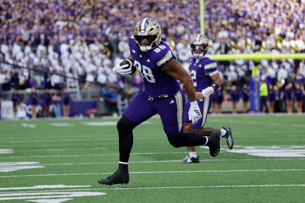 Washington tight end Quentin Moore (88) runs with the ball on a pass play against the Ohio State during the first half of an NCAA college football game, Saturday, Sept. 27, 2025, in Seattle. (AP Photo/John Froschauer)