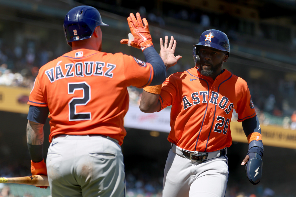 Houston Astros' Taylor Trammell (26) is congratulated by Christian Vázquez (2) after scoring on a sacrifice fly hit by Nelson Velazquez during the eighth inning of a baseball game against the San Francisco Giants in San Francisco, Wednesday, Aug. 12, 2026. (AP Photo/Jed Jacobsohn)