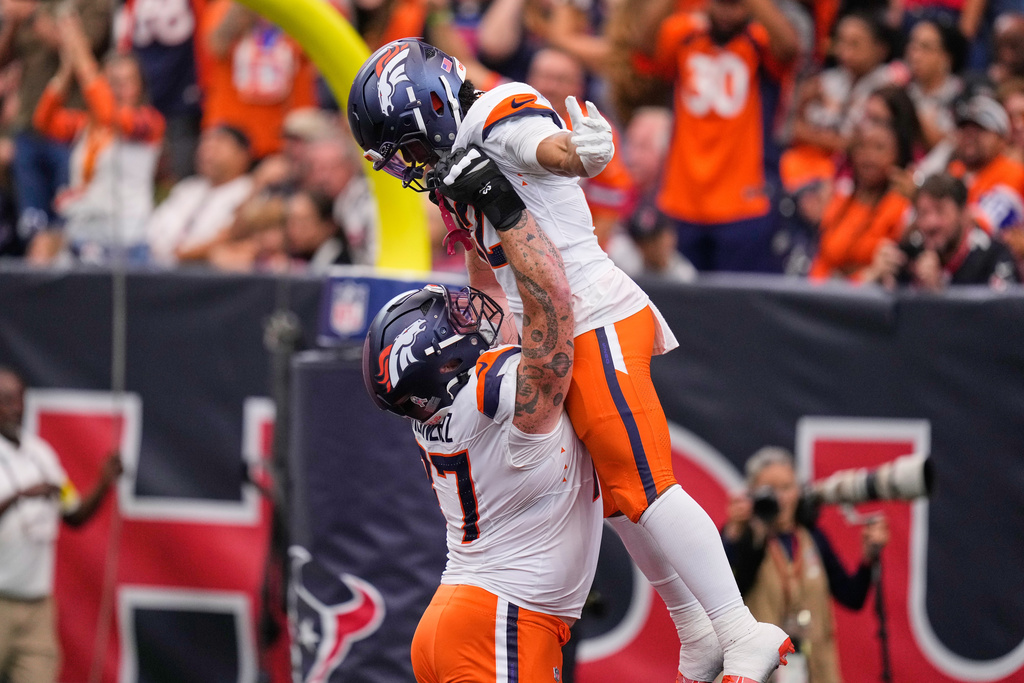Denver Broncos running back RJ Harvey, top, celebrates his touchdown catch with Quinn Meinerz (77) in the second half of an NFL football game against the Houston Texans Sunday, Nov. 2, 2025, in Houston. (AP Photo/Eric Christian Smith)