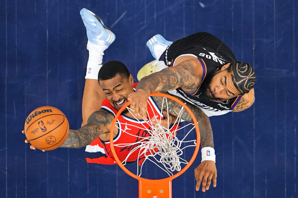 Los Angeles Clippers forward John Collins, left, shoots as Phoenix Suns center Nick Richards defends during the first half of an NBA basketball game Saturday, Nov. 8, 2025, in Inglewood, Calif. (AP Photo/Mark J. Terrill)