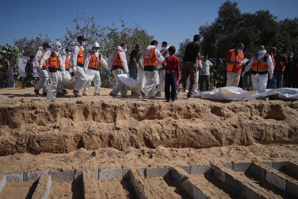 Bodies of unidentified Palestinians returned from Israel are buried in a mass grave in Deir al-Balah, Gaza Strip, Monday, Oct. 27, 2025. (AP Photo/Jehad Alshrafi)