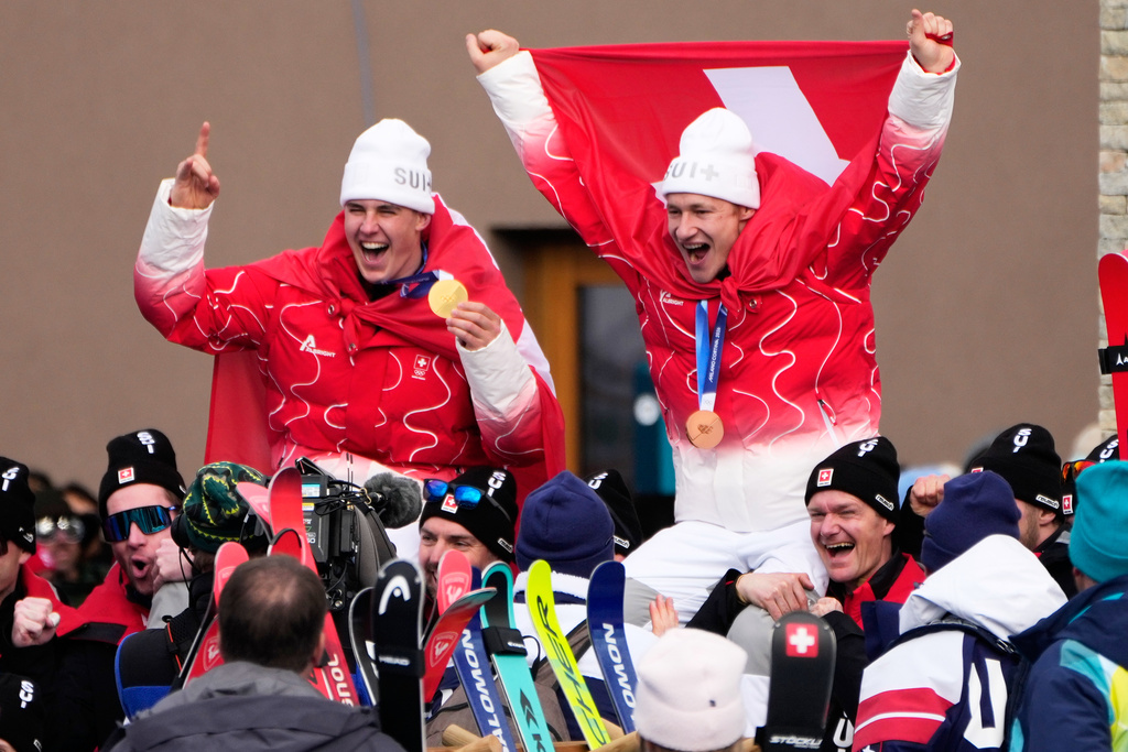 Switzerland's Franjo von Allmen, gold medalist in an alpine ski, men's super-G race, left, celebrates with bronze medalist Switzerland's Marco Odermatt, at the 2026 Winter Olympics, in Bormio, Italy, Wednesday, Feb. 11, 2026. (AP Photo/John Locher)