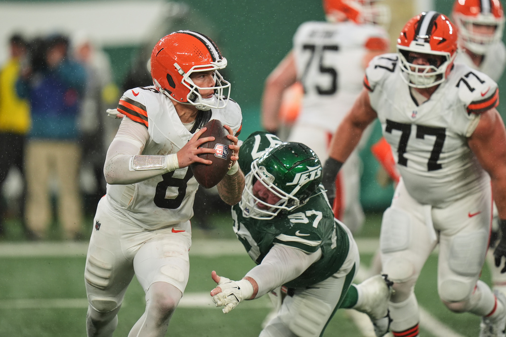 Cleveland Browns quarterback Dillon Gabriel (8) runs past a diving New York Jets defensive tackle Harrison Phillips (97) in the second half of an NFL football game, Sunday, Nov. 9, 2025, in East Rutherford, N.J. (AP Photo/Seth Wenig)