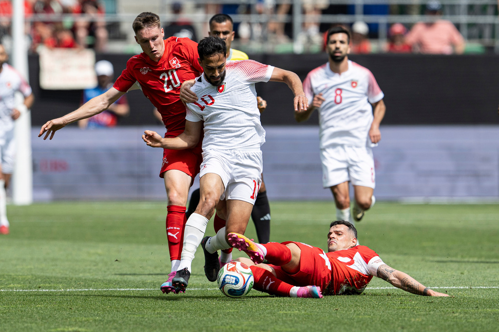 Switzerland's Michel Aebischer, left, and Granit Xhaka challenge Jordan's Musa Al-Tamari for the ball during the international friendly soccer match between Switzerland and Jordan in St. Gallen, Switzerland, Sunday, May 31, 2026. (Peter Schneider/Keystone via AP)