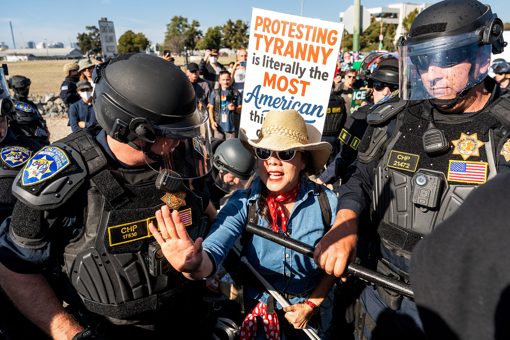 California Highway Patrol officers move back protesters who were blocking the entrance to Coast Guard Base Alameda on Thursday, Oct. 23, 2025, in Oakland, Calif. (AP Photo/Noah Berger)