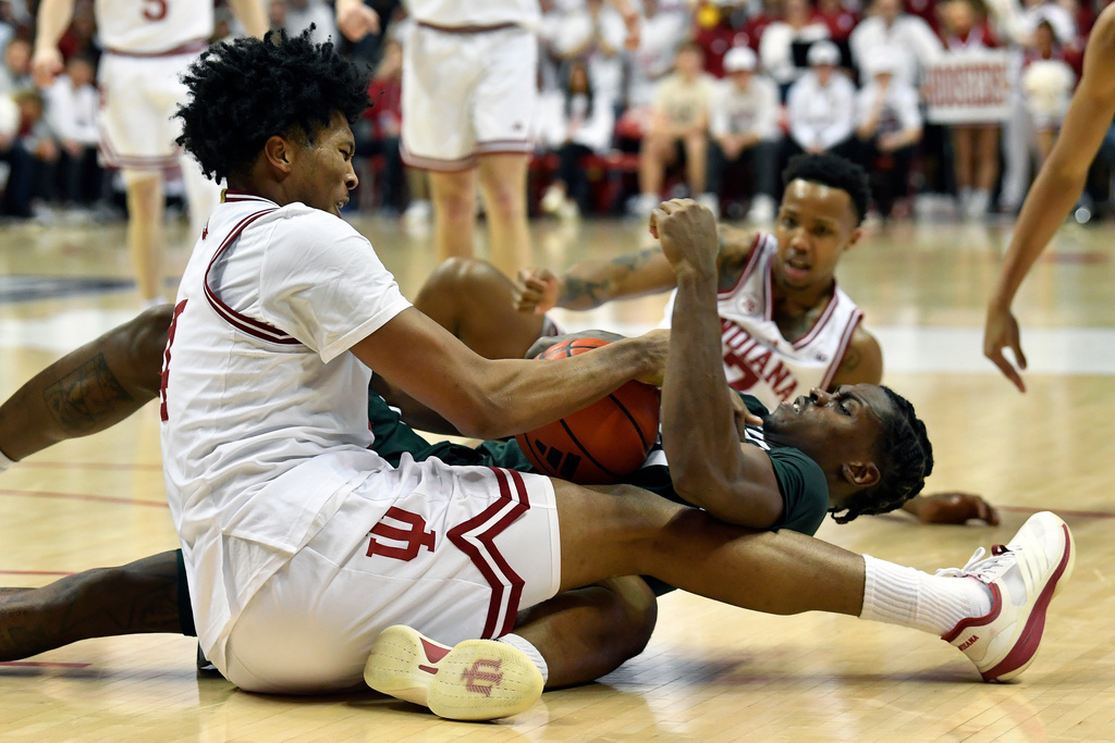 Michigan State forward Coen Carr (55) battles Indiana forward Sam Alexis (4) for a loose ball during the second half of an NCAA college basketball game in Bloomington, In., Sunday, March 1, 2026. (AP Photo/Timothy D. Easley)