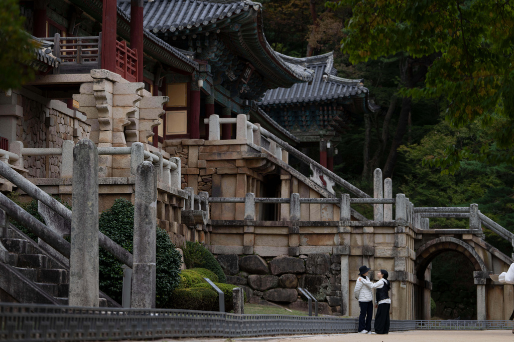 Visitors chat near Bulguksa Temple where preparations are taking place ahead of events for attendees of the Asia-Pacific Economic Cooperation (APEC) summits in Gyeongju, South Korea, Thursday, Oct. 30, 2025. (AP Photo/Ng Han Guan)