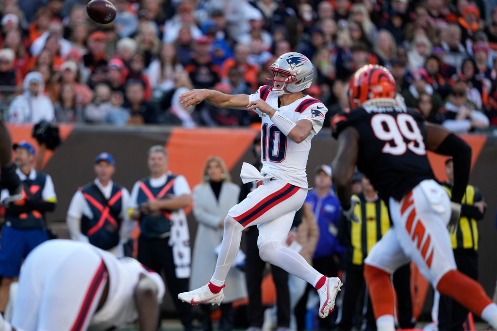New England Patriots quarterback Drake Maye (10) throws a pass ahead of Cincinnati Bengals defensive end Myles Murphy (99) during the second half of an NFL football game, Sunday, Nov. 23, 2025, in Cincinnati. (AP Photo/Carolyn Kaster)
