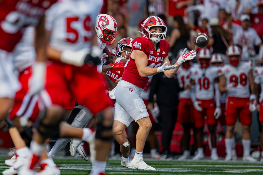 Indiana linebacker Isaiah Jones, center, makes an interception during the first half of an NCAA college football game against Western Kentucky, Saturday, Sept. 19, 2026, in Bloomington, Ind. (AP Photo/Doug McSchooler)