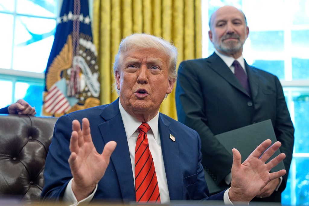 FILE - President Donald Trump speaks as he signs executive orders in the Oval Office of the White House, April 17, 2025, in Washington, as Commerce Secretary Howard Lutnick listens. (AP Photo/Alex Brandon, FIle)