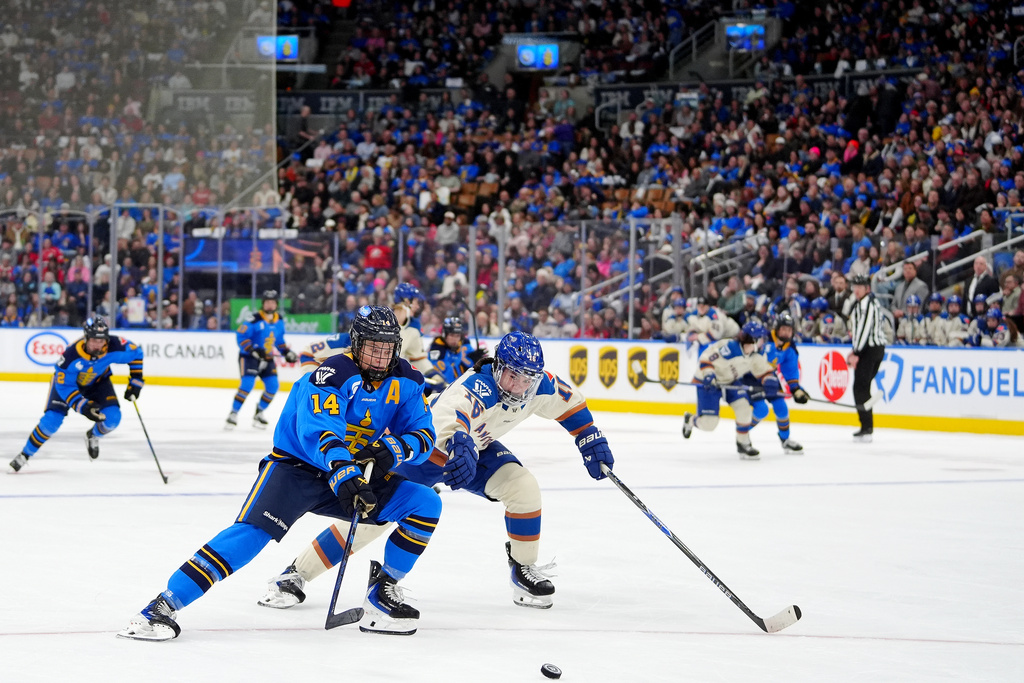 Fans look on as Toronto Sceptres defenseman Renata Fast (14) and Vancouver Goldeneyes defenseman Sophie Jaques (16) vie for control of the puck during second-period PWHL hockey game action in Toronto, Saturday, Jan. 17, 2026. (Frank Gunn/The Canadian Press via AP)
