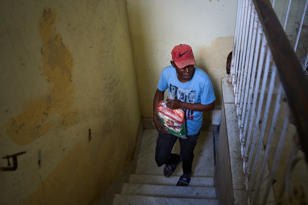 Guillermo Beltrán, a recipient of Mexican humanitarian assistance, carries a bag of donated items as he arrives at his home in Havana, Cuba, Thursday, Feb. 19, 2026. (AP Photo/Ramon Espinosa)
