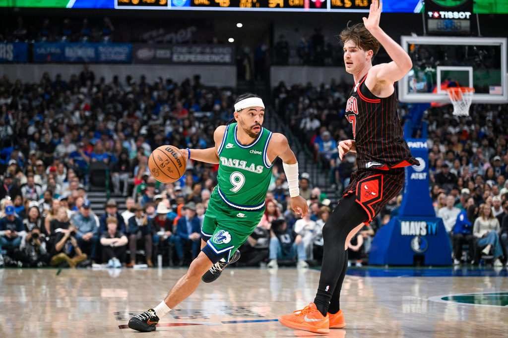Dallas Mavericks' Ryan Nembhard drives against Chicago Bulls' Lachlan Olbrich during an NBA basketball game Sunday, April 12, 2026, in Dallas. (AP Photo/Albert Pena)