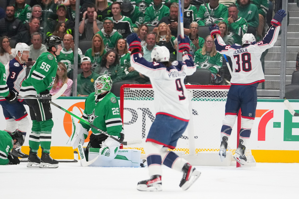 Columbus Blue Jackets center Boone Jenner (38) and teammate defenseman Ivan Provorov (9) react after Jenner scored a goal on Dallas Stars goaltender Jake Oettinger (29) during the first period of an NHL hockey game Tuesday, Oct. 21, 2025, in Dallas. (AP Photo/Julio Cortez)