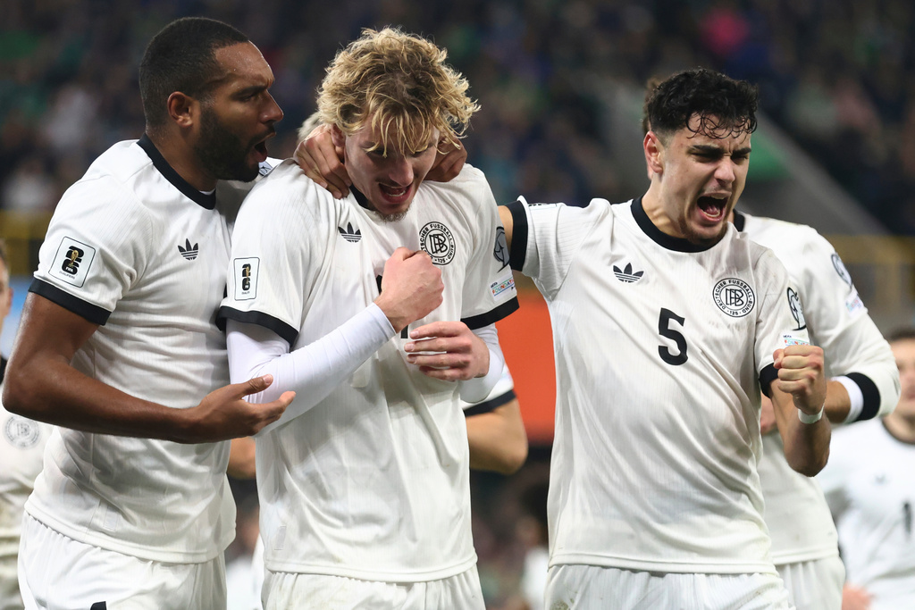 Germany's Nick Woltemade, center, celebrates with teammates Aleksandar Pavlovic, right, and Jonathan Tah, after scoring the opening goal of his team during the World Cup 2026 group A qualifying soccer match between Northern Ireland and Germany at Windsor Park stadium, in Belfast, Northern Ireland, Monday, Oct. 13, 2025. (AP Photo/Peter Morrison)