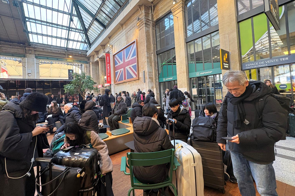 Travelers wait at the Gare du Nord station after an incident related to the power supply to trains occurred last night in part of the Channel Tunnel, affecting train and shuttle traffic. Tuesday, Dec. 30, 2025 in Paris. (AP Photo/Christophe Ena)