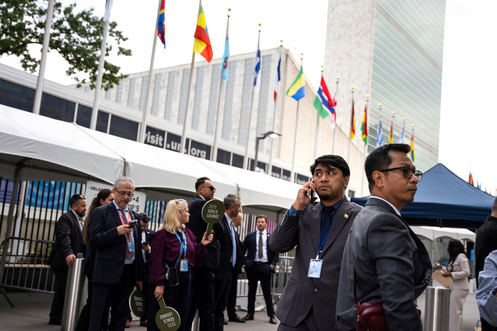 FILE - People stand outside the United Nations Headquarters on the first day of the 80th session of the U.N. General Assembly, Monday, Sept. 22, 2025. (AP Photo/Angelina Katsanis, File)