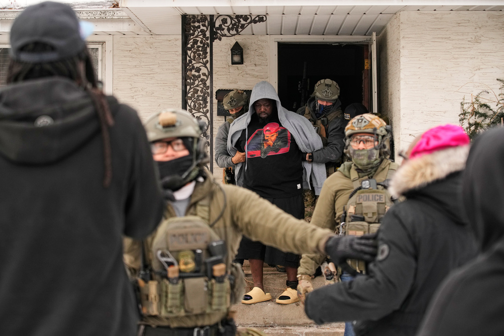 A man is arrested by federal immigration officers Sunday, Jan. 11, 2026, in Minneapolis. (AP Photo/John Locher)