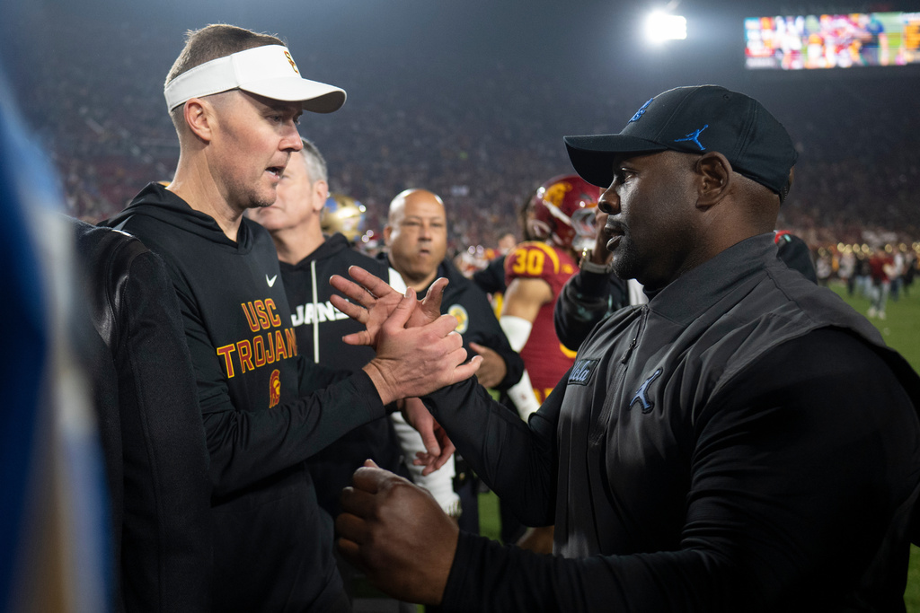 Southern California head coach Lincoln Riley, left, and UCLA interim head coach Tim Skipper shake hands after an NCAA college football game Saturday, Nov. 29, 2025, in Los Angeles. (AP Photo/Kyusung Gong)