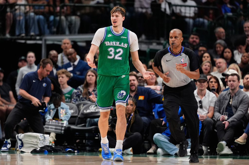Dallas Mavericks forward Cooper Flagg (32) reacts to play as referee Sean Corbin, right, jogs upcourt in the second half of an NBA basketball game against the Orlando Magic Friday, April 3, 2026, in Dallas. (AP Photo/Tony Gutierrez)