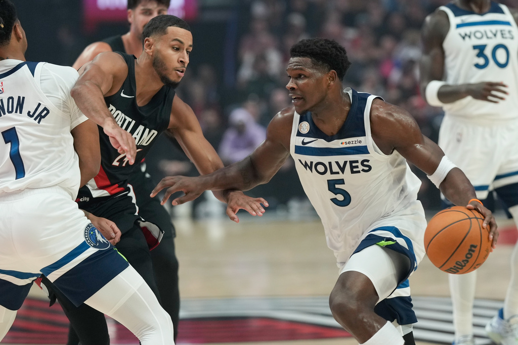 Minnesota Timberwolves guard Anthony Edwards (5) drives past Portland Trail Blazers forward Kris Murray (24) during the first half of an NBA basketball game on Wednesday, Oct. 22, 2025, in Portland, Ore. (AP Photo/Jenny Kane)