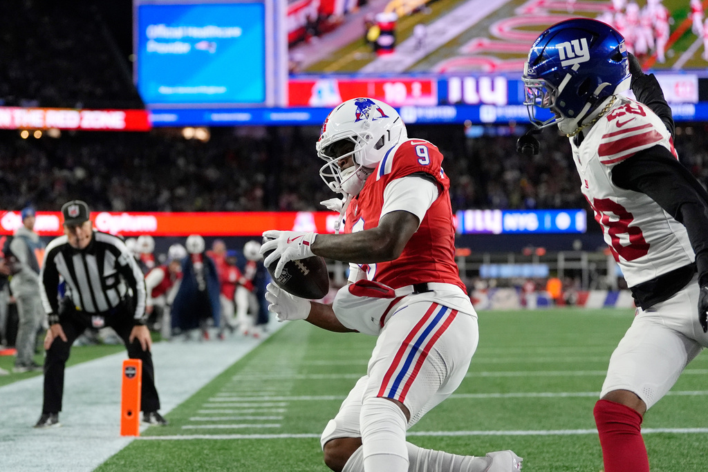 New England Patriots wide receiver Kayshon Boutte (9) catches a pass for a touchdown against New York Giants cornerback Cor'Dale Flott, right, during the first half of an NFL football game on Monday, Dec. 1, 2025, in Foxborough, Mass. (AP Photo/Charles Krupa)