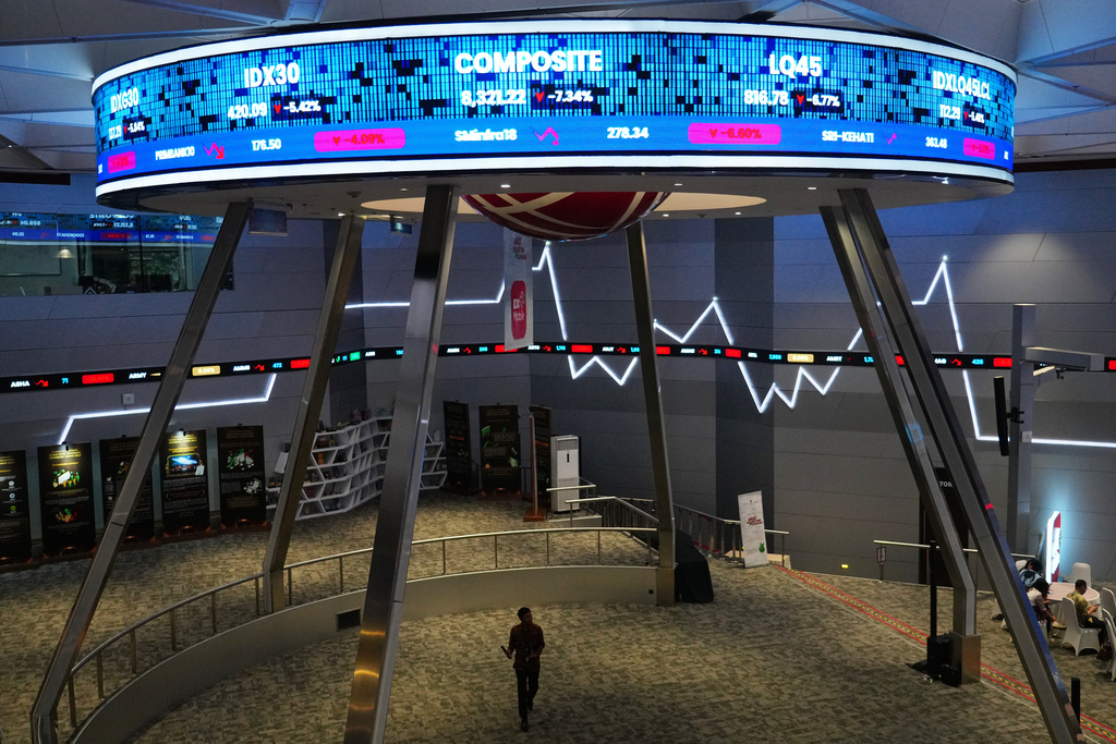 A man walks past an electronic board displaying stock prices and Jakarta Stock Exchange Composite Index, at the Indonesia Stock Exchange in Jakarta, Indonesia, Wednesday, Jan. 28, 2026. (AP Photo/Tatan Syuflana)