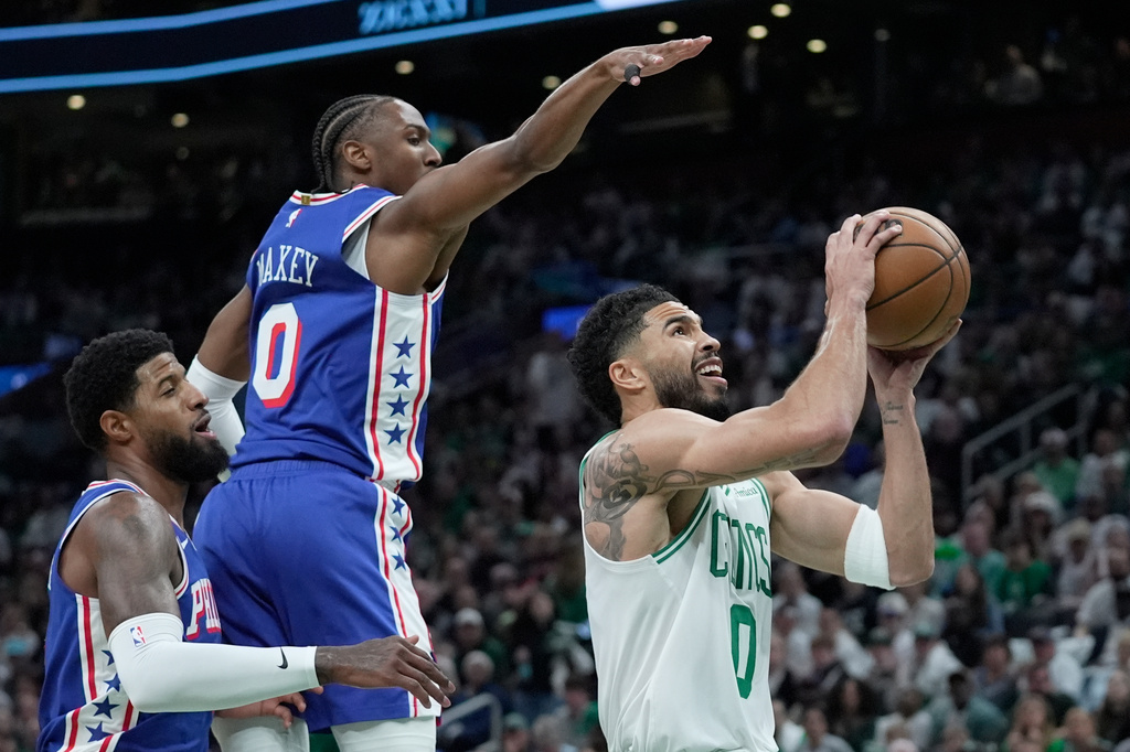 Boston Celtics forward Jayson Tatum, right, goes for a layup against Philadelphia 76ers guard Tyrese Maxey, second from left, during the first half in Game 1 of a first-round NBA playoffs basketball game, Sunday, April 19, 2026, in Boston. (AP Photo/Robert F. Bukaty)
