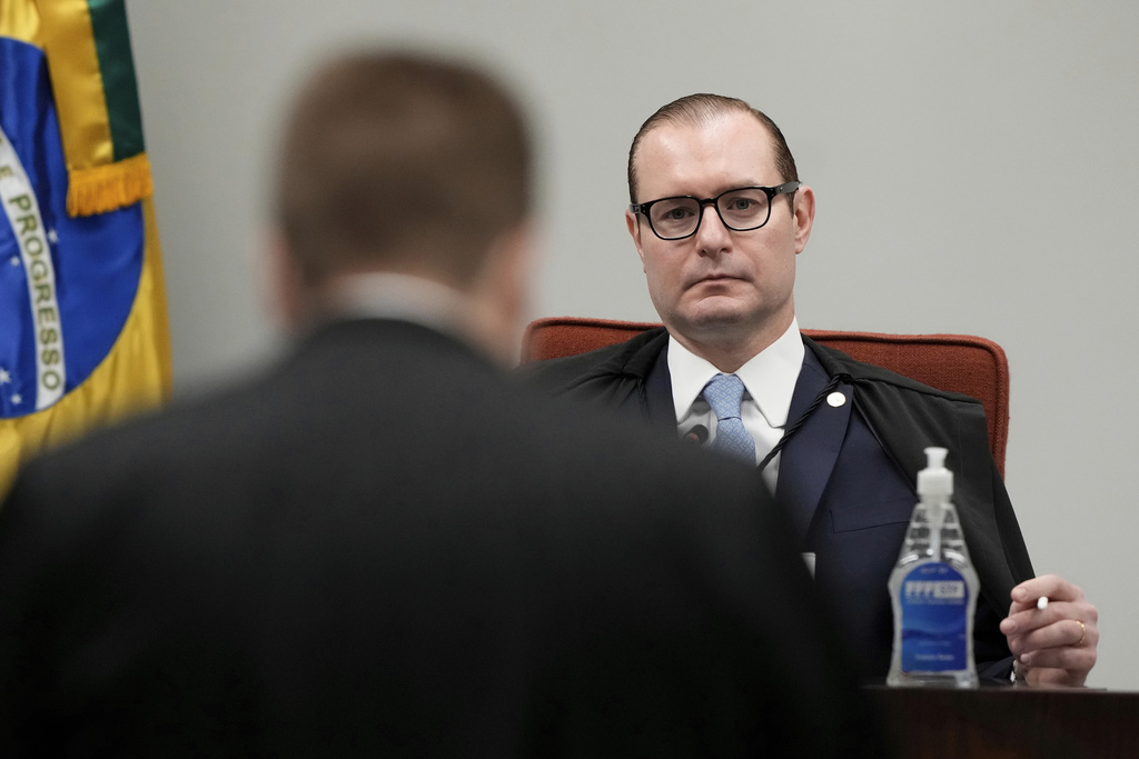 Lawyer for Gen. Augusto Heleno, who was the Minister of the Institutional Security Cabinet under Brazil's former President Jair Bolsonaro, left, speaks before Supreme Court Justice Cristiano Zanin, chairman of the panel, during the verdict and sentencing phase of a Supreme Court trial for those charged in an alleged coup plot to keep Bolsonaro in office after his 2022 election defeat, in Brasilia, Brazil, Wednesday, Sept. 3, 2025. (AP Photo/Eraldo Peres)
