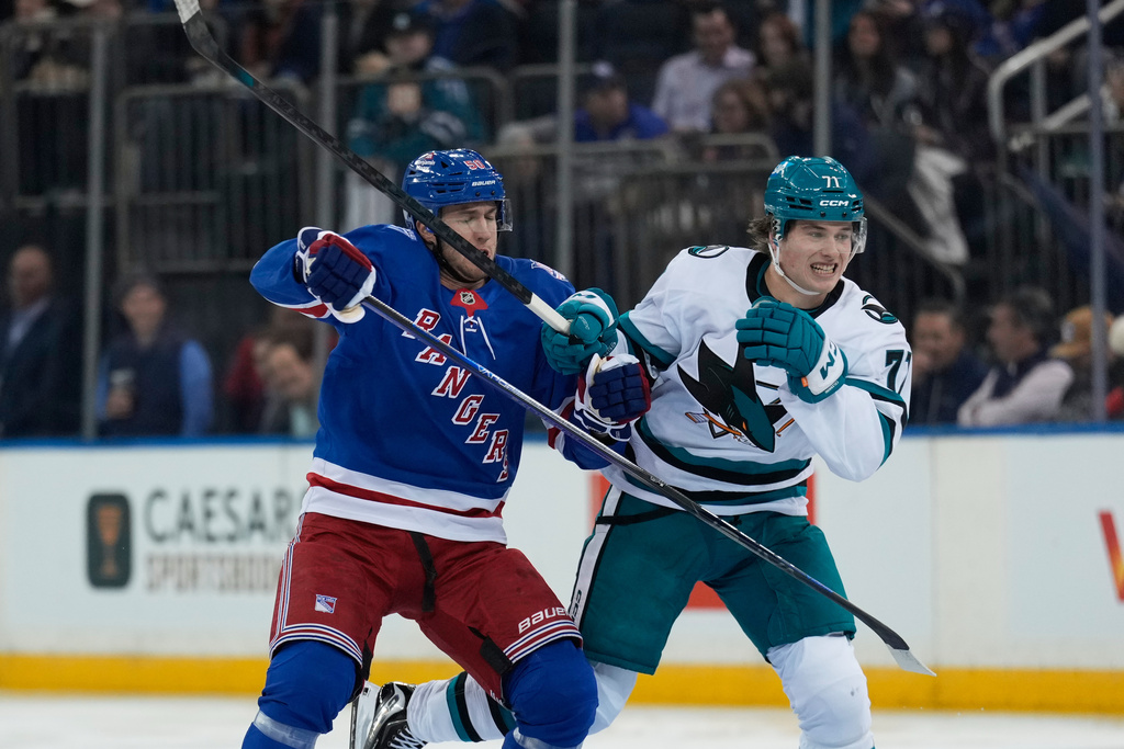 New York Rangers' Will Cuylle, left, and San Jose Sharks' Macklin Celebrini battle for position during the first period of an NHL hockey game in New York, Thursday, Oct. 23, 2025. (AP Photo/Seth Wenig)