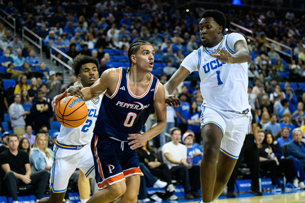Pepperdine guard Styles Phipps (0) drives the ball while contacted by UCLA guard Donovan Dent, left, during the first half of an NCAA college basketball game, Friday, Nov. 7, 2025, in Los Angeles. (AP Photo/William Liang)