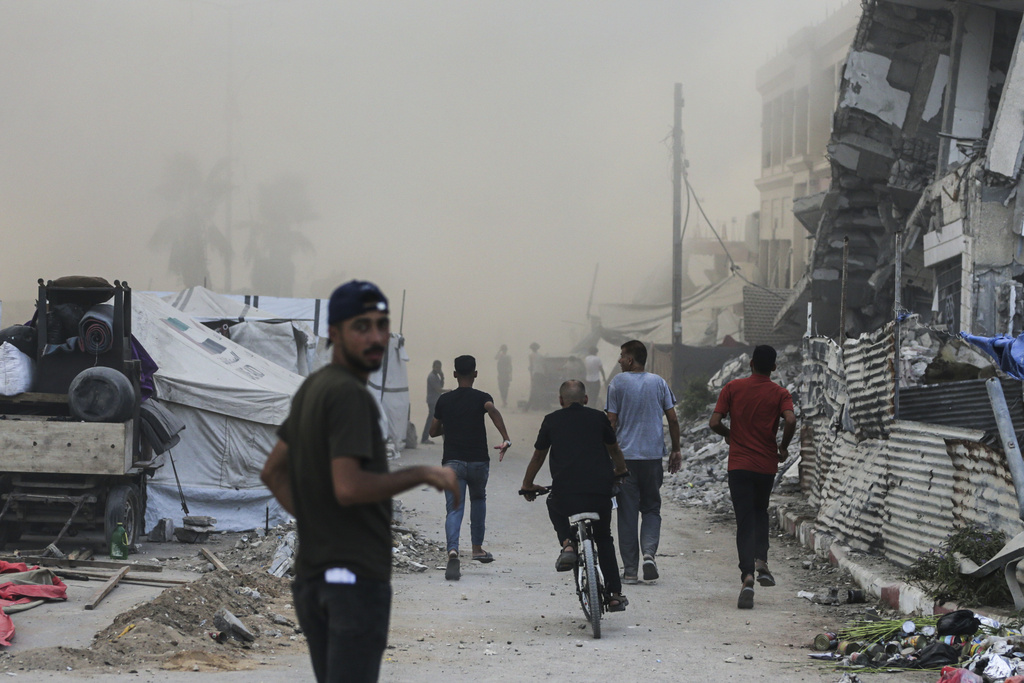 Palestinians rush to the site of an Israeli army airstrike on a high-rise building in Gaza City, Friday, Sept. 5, 2025, after the Israeli army issued a prior warning. (AP Photo/Yousef Al Zanoun)
