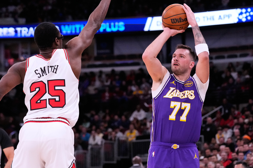 Los Angeles Lakers guard Luka Doncic, right, prepares to shoot against Chicago Bulls forward Jalen Smith, left, during the first half of an NBA basketball game in Chicago, Monday, Jan. 26, 2026. (AP Photo/Nam Y. Huh)