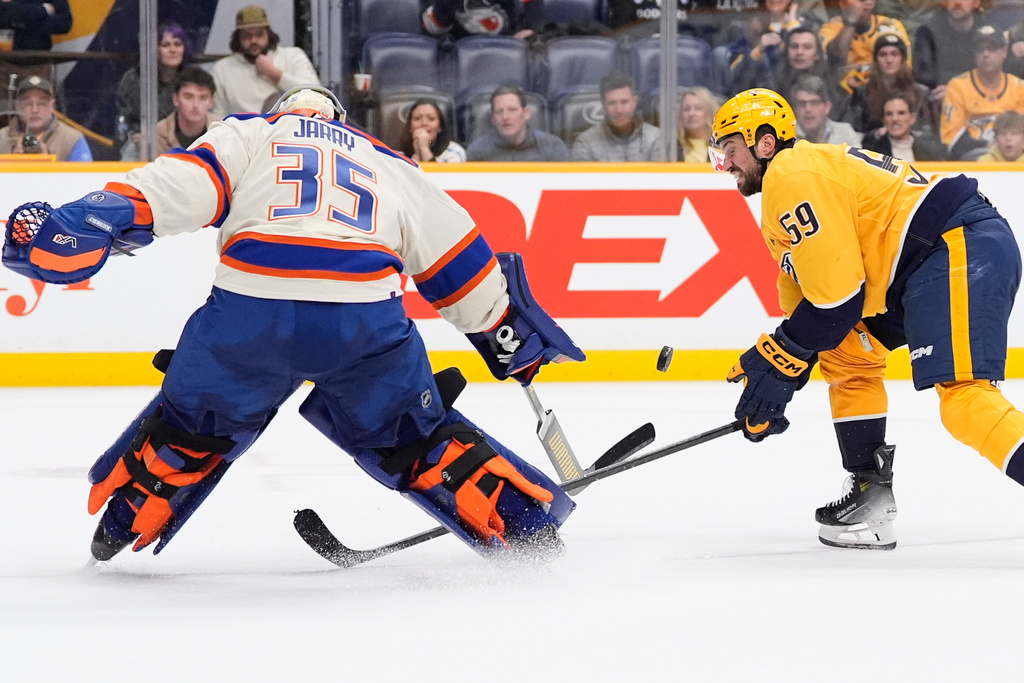 Nashville Predators defenseman Roman Josi (59) tries to get the puck past Edmonton Oilers goaltender Tristan Jarry (35) during overtime of an NHL hockey game Tuesday, Jan. 13, 2026, in Nashville, Tenn. (AP Photo/George Walker IV)